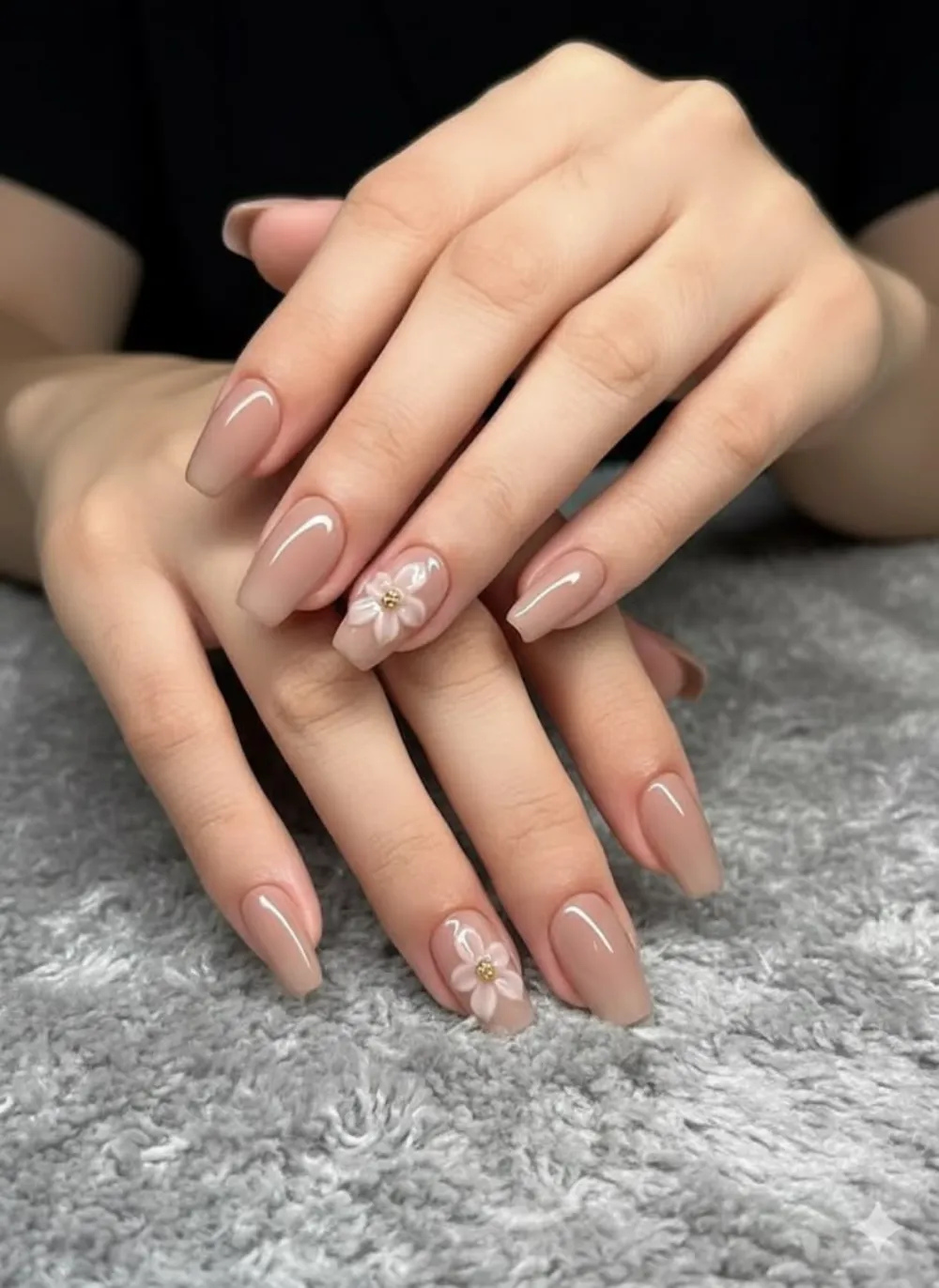 Nude coffin nails with a glossy finish and delicate 3D white flowers with gold centers.